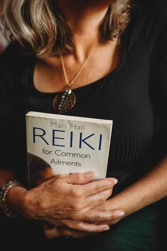 Heather hodling a Reiki for Common Elemnets book by Mari Hall